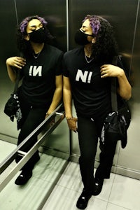 a woman in a black t - shirt standing in an elevator